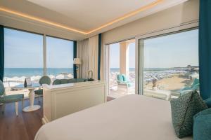 um quarto de hotel com uma cama e vista para o oceano em Riviera Resort Hotel em Lignano Sabbiadoro