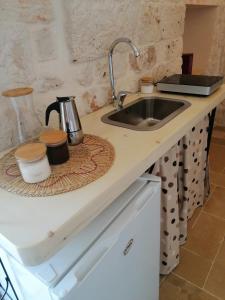 a kitchen counter top with a sink and a counter top at Trullo del Sol in Ceglie Messapica