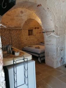 a kitchen with a counter and a bed in a room at Trullo del Sol in Ceglie Messapica