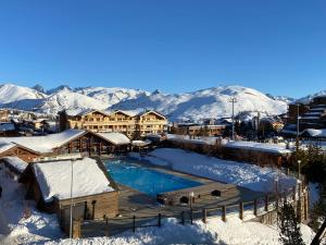 un complexe avec une piscine dans la neige dans l'établissement Alpes Sweet Home - Concorde Moon' Tain, à L'Alpe-d'Huez