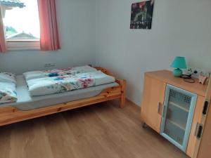 a small bedroom with a bed and a night stand at Ferienwohnung Anna in Hippach