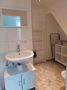 a white bathroom with a sink and a staircase at Ferien in Ostseenähe in Gelbensande