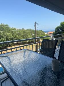 a table on a balcony with a view of the ocean at Greek Escape in Paleo Tsifliki