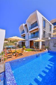 a villa with a swimming pool and a house at Casa Bi Otel in Kas