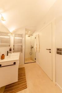 a white bathroom with a sink and a shower at ES Suites in Naples