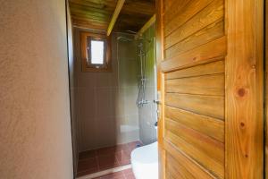 a bathroom with a shower and a toilet and a door at Bhavana Gökova in Akyaka