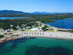 uma vista aérea de uma praia com cadeiras e água em Baia del Sole em Olbia