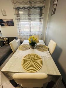 tavolo da pranzo con sedie bianche e tavolo con fiori di CasaBellocchio a Perugia