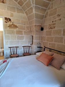 ein Schlafzimmer mit einem großen Bett in einer Steinmauer in der Unterkunft Residenza Anima Mediterranea in Francavilla Fontana