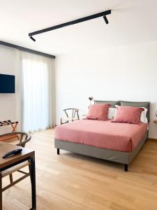 una camera da letto con un grande letto con cuscini rosa di Glass House - Smart Rooms & Parking a Lecce