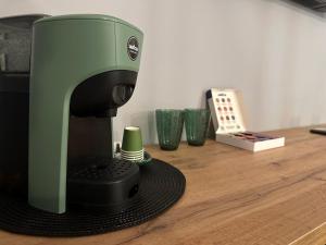 una macchinetta del caffè verde e nera seduta su un tavolo di legno di Krysos Luxury Rooms a Agrigento