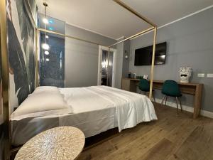 a bedroom with a bed and a table and a tv at Krysos Luxury Rooms in Agrigento