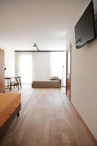 a large room with a couch and a flat screen tv at Glass House - Smart Rooms & Parking in Lecce