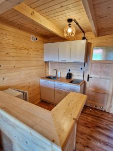 a kitchen in a wooden cabin with a wooden table at Domki i pokoje Daglezja pod Górą Żar in Międzybrodzie Żywieckie