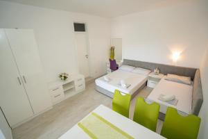 a bedroom with a bed and a table and chairs at Garden Resort - Apartments Maslina in Potocnica +38 photos