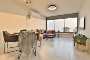 a living room with a table and a couch at Beachfront Elegance - Luxe Abode! in Netanya