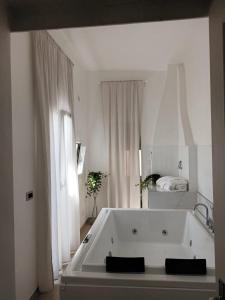 uma grande banheira branca num quarto branco em Geometric Hermes Bianca em Palo del Colle