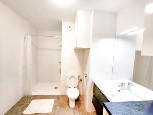 La salle de bains blanche est pourvue de toilettes et d'un lavabo. dans l'établissement O'Cap YourHostHelper, à Antibes