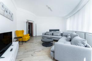 波傑布拉迪的住宿－Apartmán Riegrovo náměstí，客厅配有灰色的沙发和黄色的椅子