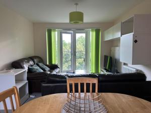 uma sala de estar com uma mesa e um sofá em Cosy 2 Bedrooms 2 Bathrooms em Basingstoke