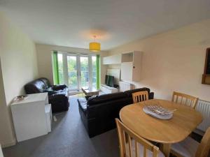 a living room with a table and a couch at Cosy 2 Bedrooms 2 Bathrooms in Basingstoke