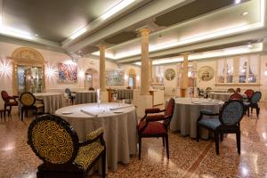 サン・ピエトロ・イン・カリアーノにあるビブロス アート ホテル ヴィラ アミスタのテーブルと椅子が備わるレストラン