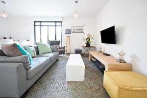a living room with a couch and a tv at NOGA vibes 2BR in JAFFA by Holyguest in Tel Aviv