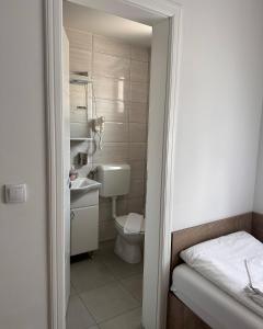 a small bathroom with a toilet and a sink at Motel Centar in Bijeljina