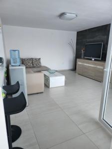 sala de estar con TV y suelo blanco en Apartments Merin, en Utjeha
