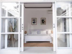1 dormitorio con 1 cama a través de una puerta corredera de cristal en Casa Majorca at Ulu, en Uluwatu