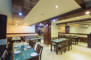 - un restaurant avec des tables et des chaises dans une salle dans l'établissement Ginger Katra, à Katra