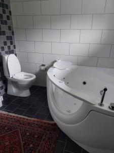 Villa med sjöutsikt في Immeln: حمام مع حوض استحمام أبيض ومرحاض