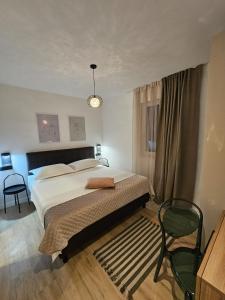 a bedroom with a large bed and a chair at Villa LUX Apartments in Rogoznica