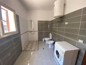 a bathroom with a washing machine and a toilet at Villa MINO in Shkodër