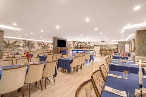 una sala da pranzo con tavoli e sedie blu di GRAND ANİ HOTEL a Kars