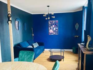 een blauwe woonkamer met een blauwe bank en een tafel bij Confort - 4 pers - WIFI - plage à 400 m in Berck-sur-Mer