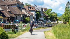 mężczyzna jeżdżący rowerem po drodze w wiosce w obiekcie Atelier d artiste 
