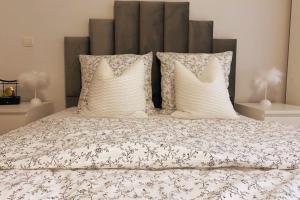 a bed with three pillows and a headboard at Les Grenats in Conflans-Sainte-Honorine