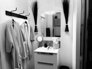W białej łazience znajduje się umywalka i lustro. w obiekcie Atelier d artiste 