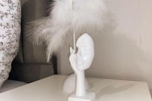 a white toy with feathers on top of a table at Les Grenats in Conflans-Sainte-Honorine