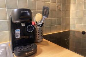 a kitchen counter with a black coffee maker on it at Les Grenats in Conflans-Sainte-Honorine