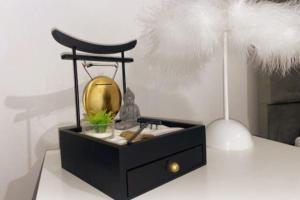 a black dresser with a clock on a table at Les Grenats in Conflans-Sainte-Honorine +5 photos