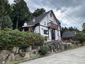 une maison blanche sur le côté d'une route dans l'établissement 山樹荘, à Amagase