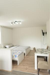 a white room with two beds and a table at Sobe Jovan in Soko Banja