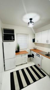 a kitchen with white cabinets and a black and white rug at Warszawa Wola Pokoje in Warsaw