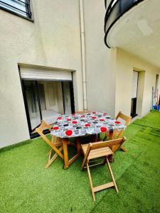 une table et des chaises assises sur une pelouse avec une table et des chaises dans l'établissement Centre ville Nogent Sur Marne, appartement standing, à Nogent-sur-Marne