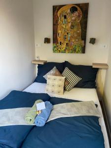 布達佩斯的住宿－Mrs. Columbo's Flat，一间卧室配有一张带蓝色枕头的床和一幅画
