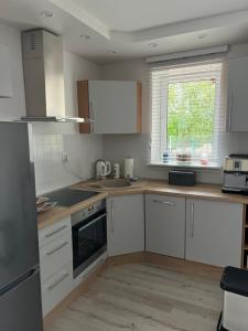 a kitchen with white cabinets and a window at Mieszkanie - Apartament in Dąbrowa