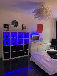 ケルンにあるStudio El Guessのベッドルーム1室(ドレッサー、青い照明付きのベッド1台付)