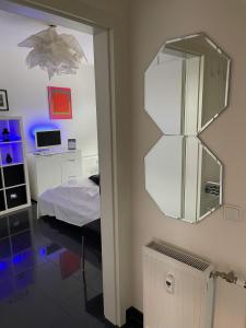 ケルンにあるStudio El Guessのベッド1台と壁掛け鏡が備わる客室です。